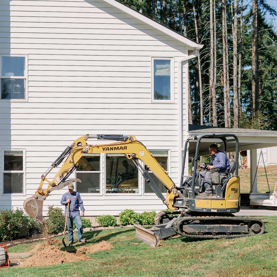 Excavator with two men working - Goodman Sanitation Septic Solutions in Portland OR