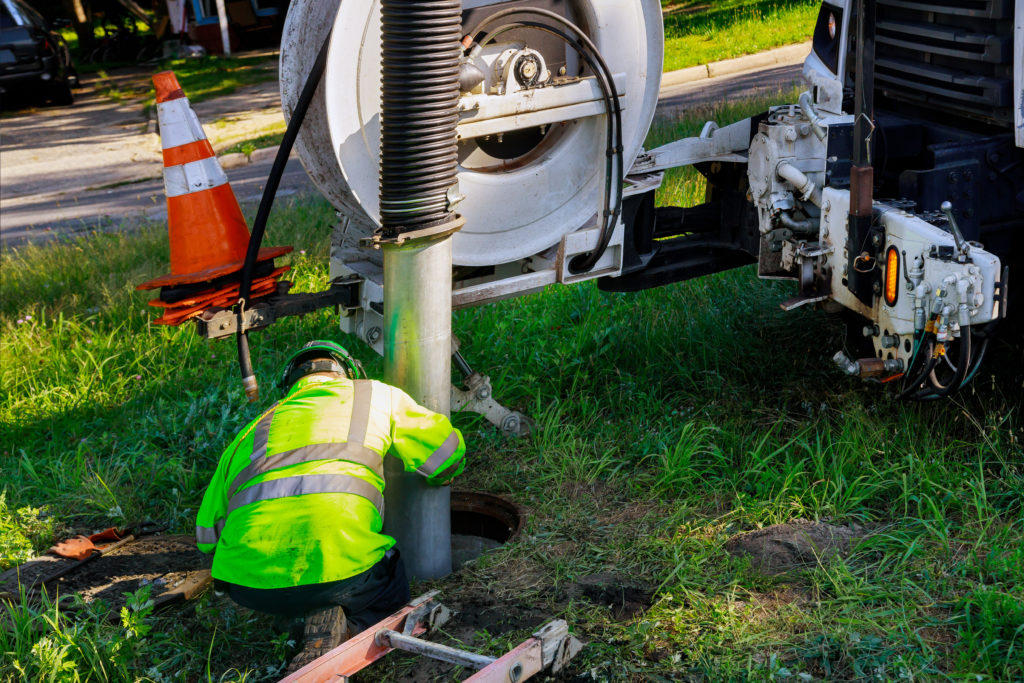 worker pumping septic tank behind pump truck Septic Inspections by Goodman Sanitation in Troutdale OR