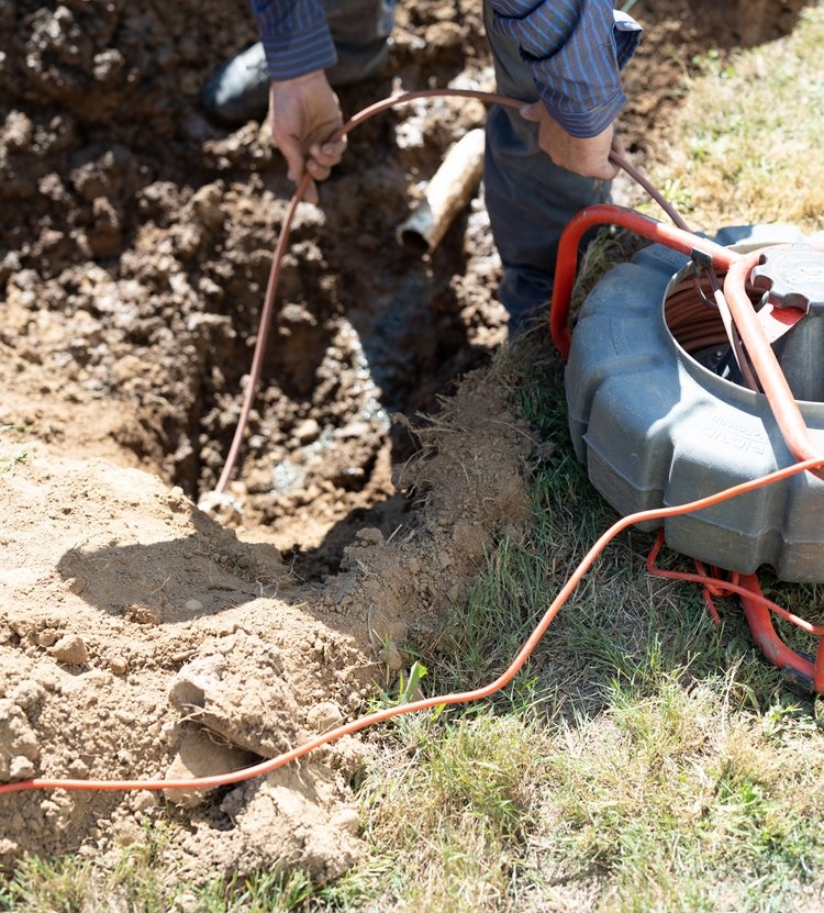 worker feeding line through septic system Septic Inspections by Goodman Sanitation in Troutdale OR