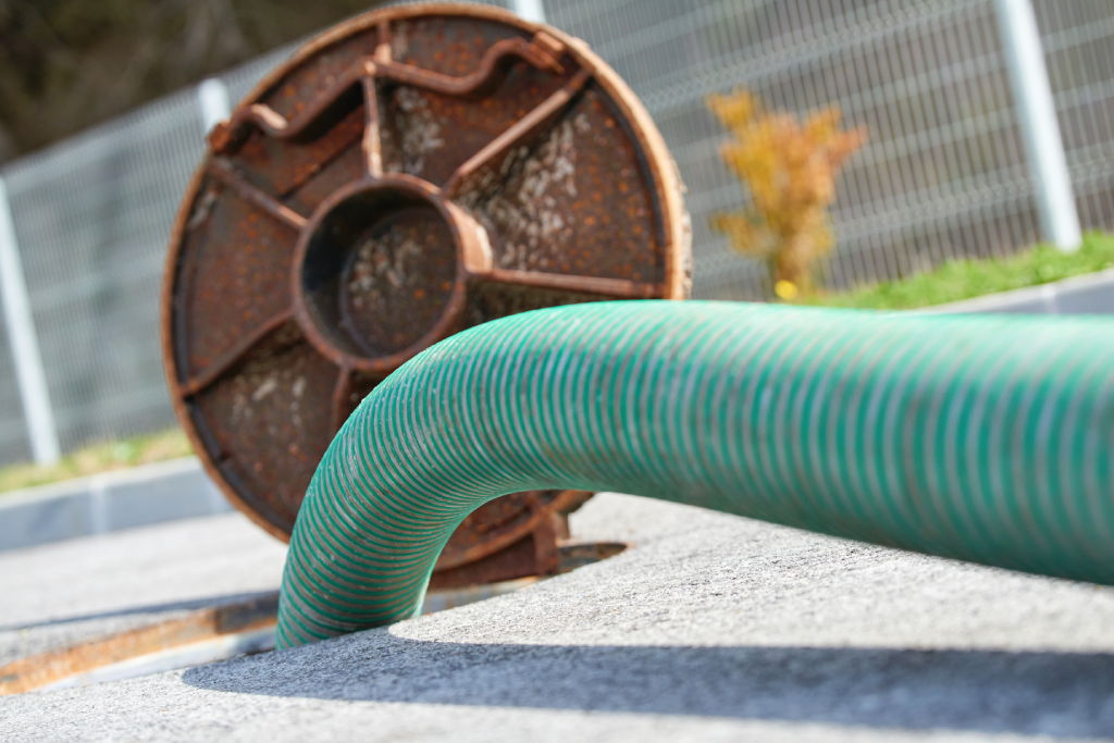 Green septic cleaning hose in a septic tank